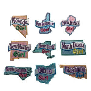 May include: A collection of embroidered patches featuring state outlines with the word "Girl" and the state name. States include Nevada, New Hampshire, New Jersey, New Mexico, New York, North Dakota, North Carolina, Ohio, and Oklahoma. Each patch has a unique color scheme.