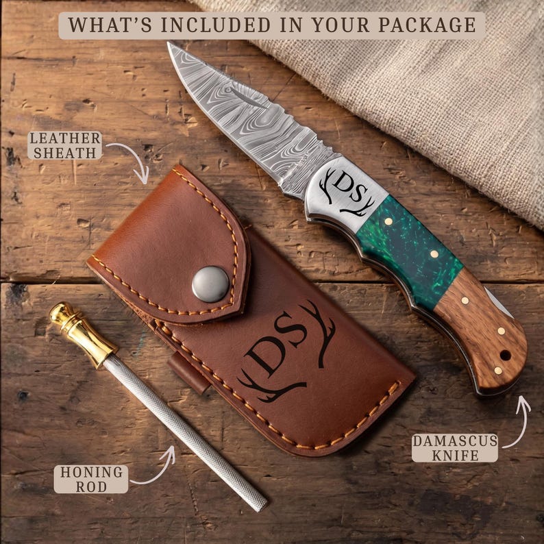 May include: A Damascus steel folding knife with a green and wood handle, a brown leather sheath, and a metal honing rod. The knife blade and sheath are engraved with the letters DS and antler icons. Text reads: WHAT'S INCLUDED IN YOUR PACKAGE.