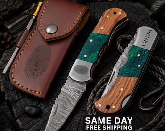May include: A folding pocket knife with a Damascus steel blade, a handle featuring wood and green resin, and a metal bolster. A second folded knife with the name HENRY engraved on the bolster, and a brown leather sheath with a fingerprint design.
