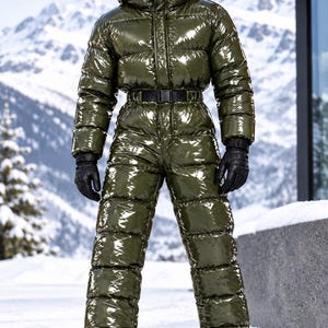 Può includere: Una tuta da neve imbottita color verde oliva lucido, caratterizzata da collo alto, cappuccio e cintura nera con fibbia in vita. Il capo presenta un design trapuntato, maniche lunghe e gambe intere, abbinato a guanti in pelle nera e stivali neri.