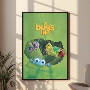 May include: A framed poster featuring the movie title A Bug's Life in yellow text. The artwork displays a large green leaf with a hole in the center, revealing a blue ant, a purple ant, a green caterpillar, and a red ladybug character.
