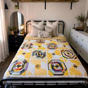May include: A bed quilt featuring a repeating pattern of octagonal blocks in various colours including red, green, blue, and purple, set against a bright yellow and white background with intricate stitching and a yellow border on a black metal bed frame.