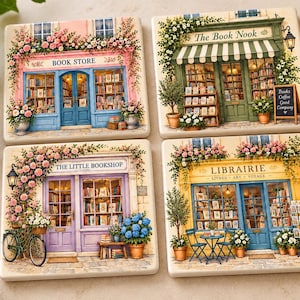 May include: Four square ceramic coasters featuring detailed illustrations of storefronts. One shows a pink Book Store, another a green The Book Nook, a purple The Little Bookshop, and a yellow Librairie with blue doors and floral accents.