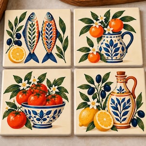 May include: A set of four square ceramic coasters featuring colorful illustrations. One shows two fish with lemons and olives, another an orange tree in a blue and white pitcher, a third tomatoes in a bowl, and the fourth a lemon and olive oil cruet.