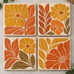 May include: A set of four square coasters featuring a cream background with floral illustrations in shades of orange, yellow, and brown. Each coaster displays a unique botanical arrangement of stylized flowers and leaves with bold outlines.