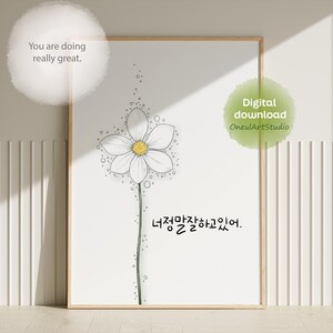 May include: A framed wall art print featuring a single white flower with a yellow center and a green stem. The illustration includes small circles surrounding the flower and the English text "You are doing really great." and Korean text "너정말잘하고있어."