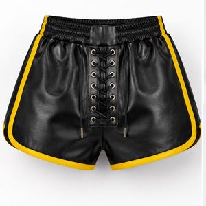 May include: Black shorts with a smooth finish featuring a central lace-up detail with silver-toned metal eyelets and black laces. The shorts have a high elastic waistband and vibrant yellow piping along the side seams and curved leg openings.