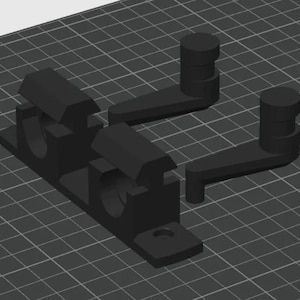 May include: A set of black 3D-printed components, likely for a mechanical assembly. The parts include a base with cylindrical holes and angled supports, along with separate arm-like pieces. The design suggests a functional, possibly industrial, application.