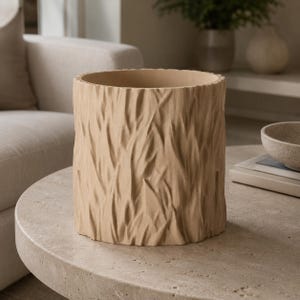 May include: A cylindrical planter with a light beige matte finish and a textured exterior that mimics the appearance of tree bark. The vessel features a wide, open top and a flat base, designed with a consistent vertical pattern throughout.