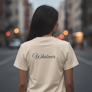 Op de afbeelding: Een crèmekleurig T-shirt met korte mouwen en het woord "Whatever..." in een zwart, cursief lettertype op de bovenrug gedrukt. Het kledingstuk heeft een ronde hals en een standaard pasvorm, wat zorgt voor een eenvoudig ontwerp.