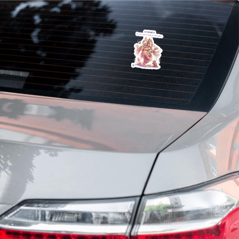 May include: A die-cut vinyl sticker featuring a colorful illustration of the Hindu deity Ganesha in a standing pose, adorned with ornate jewelry and clothing, with the text "VAKRATUNDA MAHAKAYA SURYAKOTI SAMAPRABHA" printed in a white banner above.
