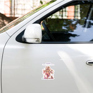 May include: A white car door featuring a rectangular sticker with a colorful illustration of the deity Ganesha. The sticker includes the text "GANAPATI" and "Lord of wisdom and success" in a purple font, with a small letter D in the corner.