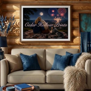Könnte beinhalten: Ein gerahmter Kunstdruck mit dem Titel Cedar Hollow Prints, der eine nächtliche Szene mit zwei Personen und einem Hund zeigt, die auf einer Decke unter einem Vollmond und buntem Feuerwerk über einer Berglandschaft sitzen.