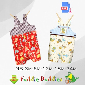 Op de afbeelding: Twee paar baby-overalls, een rode met een zwart-wit geruite top en een crèmekleurige met een blauw-wit geruite top. Beide overalls hebben een dierenprint en de tekst "NB-3M-6M-12M-18M-24M" en "Fuddie Duddies".