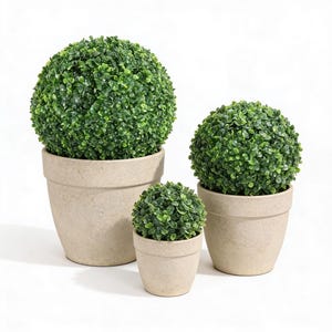 May include: Three artificial topiary plants in beige pots. The plants have dense, vibrant green foliage, shaped into spheres. The pots are different sizes, creating a tiered effect. The background is plain white, highlighting the plants.