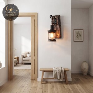 A vintage farmhouse wall sconce with a reclaimed wood plank backing and a black metal lantern suspended from a decorative scrolled iron hook and chain, perfect for entryways, porches, hallways, and covered patios.