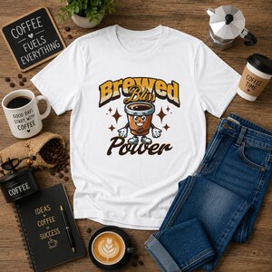 May include: White t-shirt featuring a cartoon coffee cup design with the words "Brewed Bliss Power". The image includes a coffee grinder, a mug, a notebook, a cup of coffee, and blue jeans. A sign says "Coffee Fuels Everything".