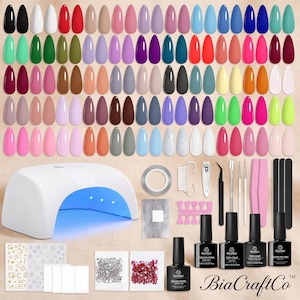 May include: A comprehensive nail art kit featuring a white UV LED nail lamp, numerous gel polish color samples in various shades, base and top coats, nail files, buffers, cuticle tools, nail stickers, and decorative rhinestones for manicure.