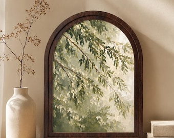 May include: An arched wall art piece featuring a painting of green tree branches and leaves against a light background, enclosed in a dark brown wooden frame. The artwork depicts a natural scene with soft light filtering through the foliage.