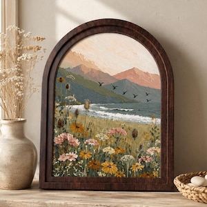 May include: An arched framed painting depicting a coastal landscape with a field of wildflowers in the foreground, a calm sea, and distant mountains under a soft sky. The artwork features textured brushstrokes and a palette of muted earth tones.