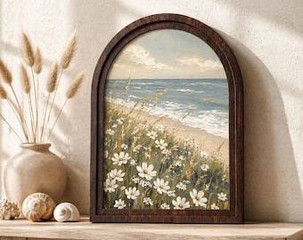 May include: An arched wooden frame containing an oil painting of a coastal scene with white flowers and tall grasses in the foreground, a sandy beach, and blue ocean waves under a cloudy sky. The artwork features textured brushstrokes throughout.