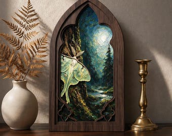 May include: A gothic-arched wooden frame containing an oil painting of a pale green luna moth resting on a tree trunk in a dark forest at night, with a bright moon illuminating the scene, set beside a dried fern in a vase and a brass candlestick.