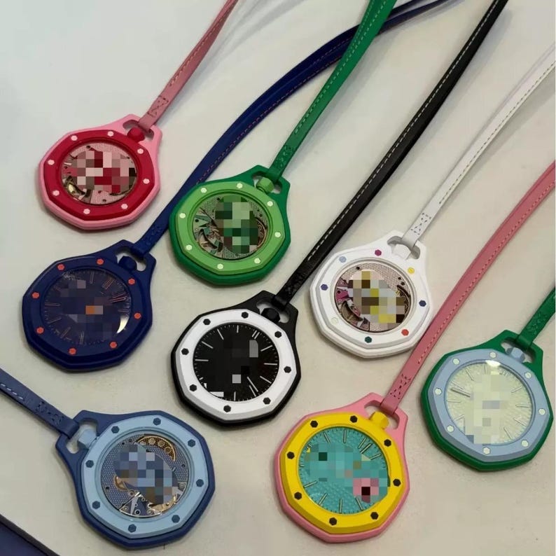 May include: A collection of eight octagonal pendant watches, each featuring a matching colored leather strap. The watches come in various colors including pink, green, dark blue, black, white, and yellow, with visible clock faces and internal mechanisms.