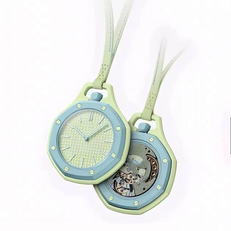 May include: Two octagonal pendant watches with light green leather straps. One watch features a light green textured dial with silver hands, while the other displays an exposed mechanical movement with a circular gear pattern and a blue bezel.