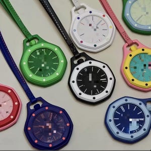 May include: A collection of octagonal pocket watches with matching colored straps. The watches feature various dial colors including green, black, white, blue, and yellow, each with contrasting hour markers and hands, arranged in a circular pattern.