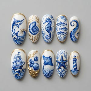 May include: A set of ten oval-shaped press-on nails featuring intricate blue and white nautical illustrations. Designs include a marlin, seashell, seahorse, fish, octopus tentacle, sailing ship, sea urchins, stingray, starfish, and a lighthouse.