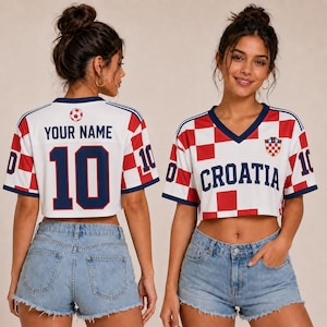 Może przedstawiać: Biało-czerwona koszulka typu crop top w szachownicę z granatowym wykończeniem. Z przodu znajduje się napis CROATIA oraz herb. Z tyłu widnieje napis YOUR NAME nad numerem 10 i ikoną piłki nożnej. Na rękawach r&oacute;wnież znajduje się numer 10.