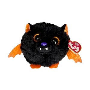 May include: A round, plush black bat toy with fuzzy texture, large orange glittery eyes, a small purple nose, and two white fangs. It features orange glittery wings and feet, and a heart-shaped red Ty tag attached to the side of its head.