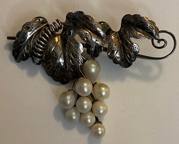 Grape branch with leaves and dangling pearls as g… - image 1