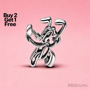 Pode incluir: Um charm prateado com um design abstrato, possivelmente uma figura ou símbolo, contra um fundo rosa. O charm tem uma superfície polida e reflexiva. O texto no canto superior esquerdo diz "Buy 2 Get 1 Free".