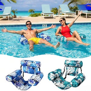Könnte beinhalten: Aufblasbarer Poolschwimmer mit blauem und weißem tropischem Blättermuster. Der Schwimmer hat eine Kopfstütze und Armlehnen für bequemes Entspannen im Wasser. Zwei Personen sind auf den Schwimmern in einem Pool zu sehen.
