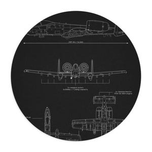May include: A circular black rug featuring a detailed white blueprint of a military aircraft. The design includes top, front, and side views, with measurements of 53ft 4in / 16.26m. Text indicates 11x weapon pylons and 16,000lbs / 7,260kg capacity, plus 2x General Electric TF34-GE-100A engine.