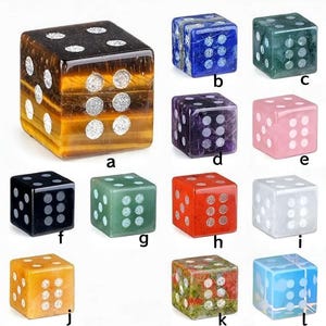 May include: A collection of twelve gemstone dice in various colors, including tiger's eye, blue, green, purple, pink, black, red, white, yellow, and a multi-colored option. Each die has white dots indicating the numbers.