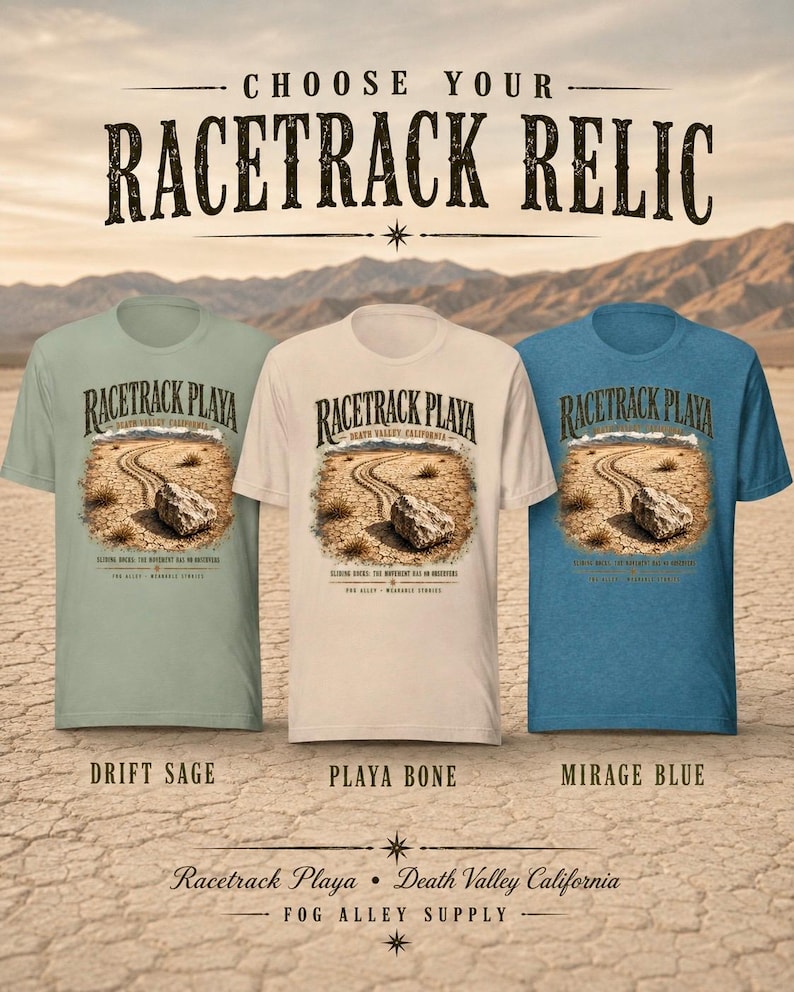 Puede incluir: Tres camisetas de manga corta en color verde salvia, hueso y azul espejismo. Cada camiseta presenta un gr&aacute;fico de una roca sobre un suelo des&eacute;rtico agrietado con el texto Racetrack Playa Death Valley California. El texto Choose Your Racetrack Relic aparece arriba.