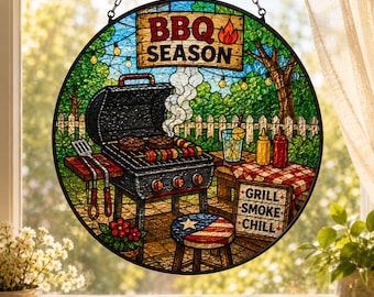 May include: Circular stained glass window art with a BBQ theme. The design shows a barbecue with food, a picnic table, and the text "BBQ SEASON" and "GRILL SMOKE CHILL". The window is framed with a black chain.