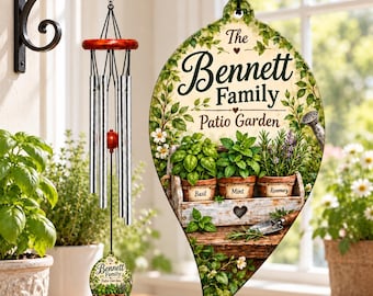 Könnte beinhalten: Ein blattförmiges Hängeschild mit der Aufschrift The Bennett Family Patio Garden, illustriert mit Basilikum-, Minz- und Rosmarintöpfen in einer Holzkiste. Daneben hängt ein Windspiel mit silbernen Metallröhren und roten Akzenten.