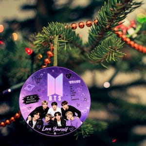 May include: A round purple ornament featuring a group photograph of seven individuals, the BTS logo, and the text "Love Yourself," "I-Purple You," "We Are Together Bulletproof," and the names of the members printed in white and black.