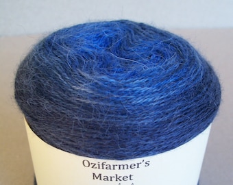 May include: A skein of blue yarn with a white label that says "Ozifarmer's Market" and "Decadence". The label also features a cartoon cow.
