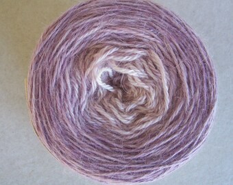 May include: A skein of yarn in a light purple and white colour combination. The yarn is wound into a ball shape.