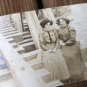 Réservé vintage 1909 dames assises sur un pont en bois sur des tréteaux, carte postale éphémère photo sépia