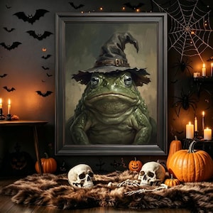 May include: A framed wall art print featuring a detailed illustration of a green toad wearing a dark, weathered witch hat with a buckle. The toad has large, expressive eyes and textured skin, presented in a dark, moody artistic style.