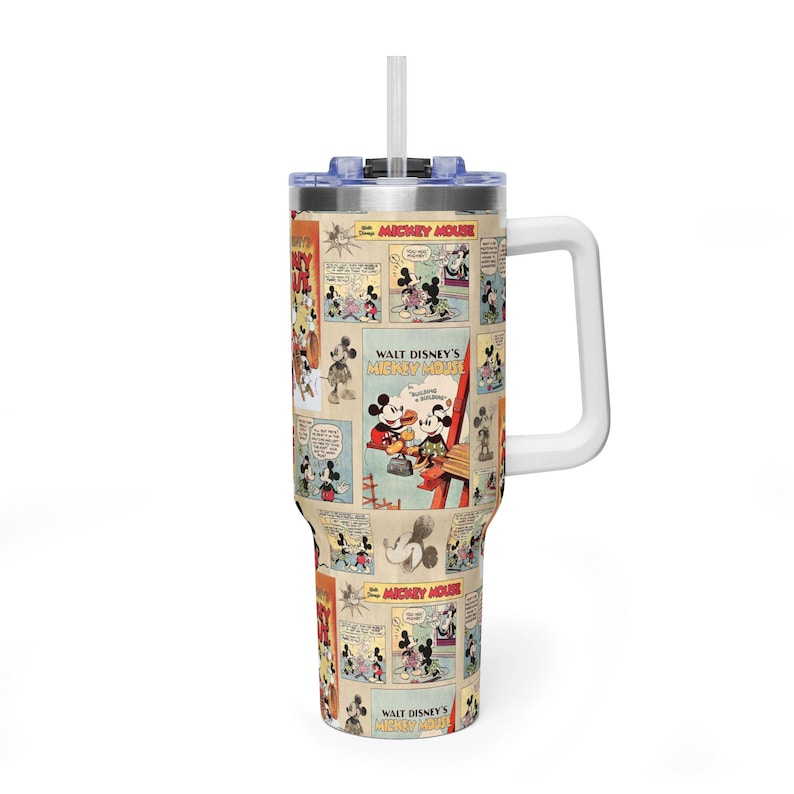May include: A large tumbler featuring a comic strip design with images of Mickey Mouse. The tumbler has a white handle, a blue lid, and a white straw. The text "WALT DISNEY'S MICKEY MOUSE" is visible on the tumbler.