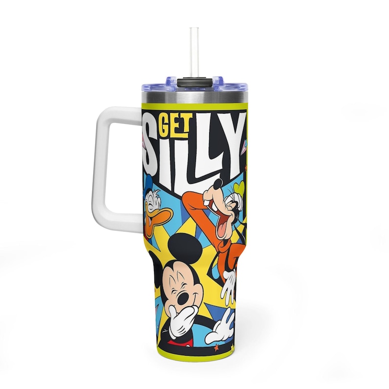 Peut inclure: Un grand gobelet isotherme avec une poign&eacute;e blanche et une paille. Le gobelet pr&eacute;sente un design color&eacute; avec Mickey Mouse, Donald Duck et Dingo, ainsi que les mots "GET SILLY". Le fond est un m&eacute;lange de jaune, de bleu et d'orange.