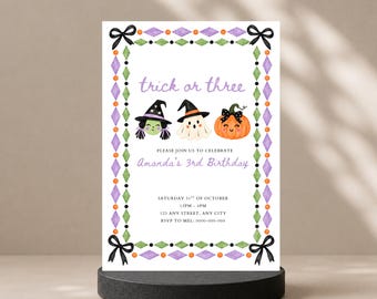 May include: A rectangular birthday invitation card featuring a border of purple diamonds, green diamonds, and orange dots with black bows at the corners. The text reads trick or three, Amanda's 3rd Birthday, and event details on a white background.