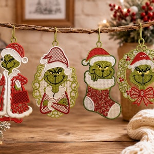 May include: Four embroidered hanging ornaments featuring a green character with yellow eyes wearing a red and white Santa hat. The designs include the character holding a candy cane, standing with arms crossed, peeking from a stocking, and inside a wreath.