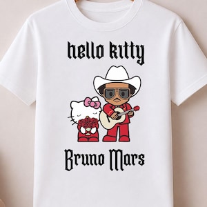 May include: White t-shirt featuring a graphic of Hello Kitty and Bruno Mars in a cowboy hat playing a guitar. The text "hello kitty" and "Bruno Mars" are printed in black gothic font. The shirt is hanging on a wooden hanger.